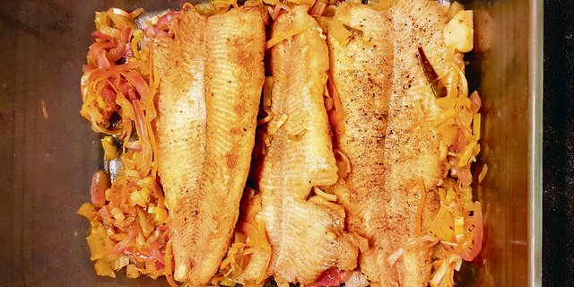 Angebratenen Fisch auf einen Teil des Gemüses legen. 