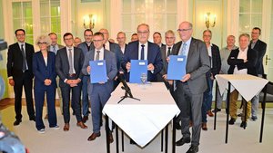 Alle Unterzeichnende Alle Unterzeichnenden scharen sich hinter Bundesrat Guy Parmelin, um bildhaft ihre Einigkeit zu demonstrieren.