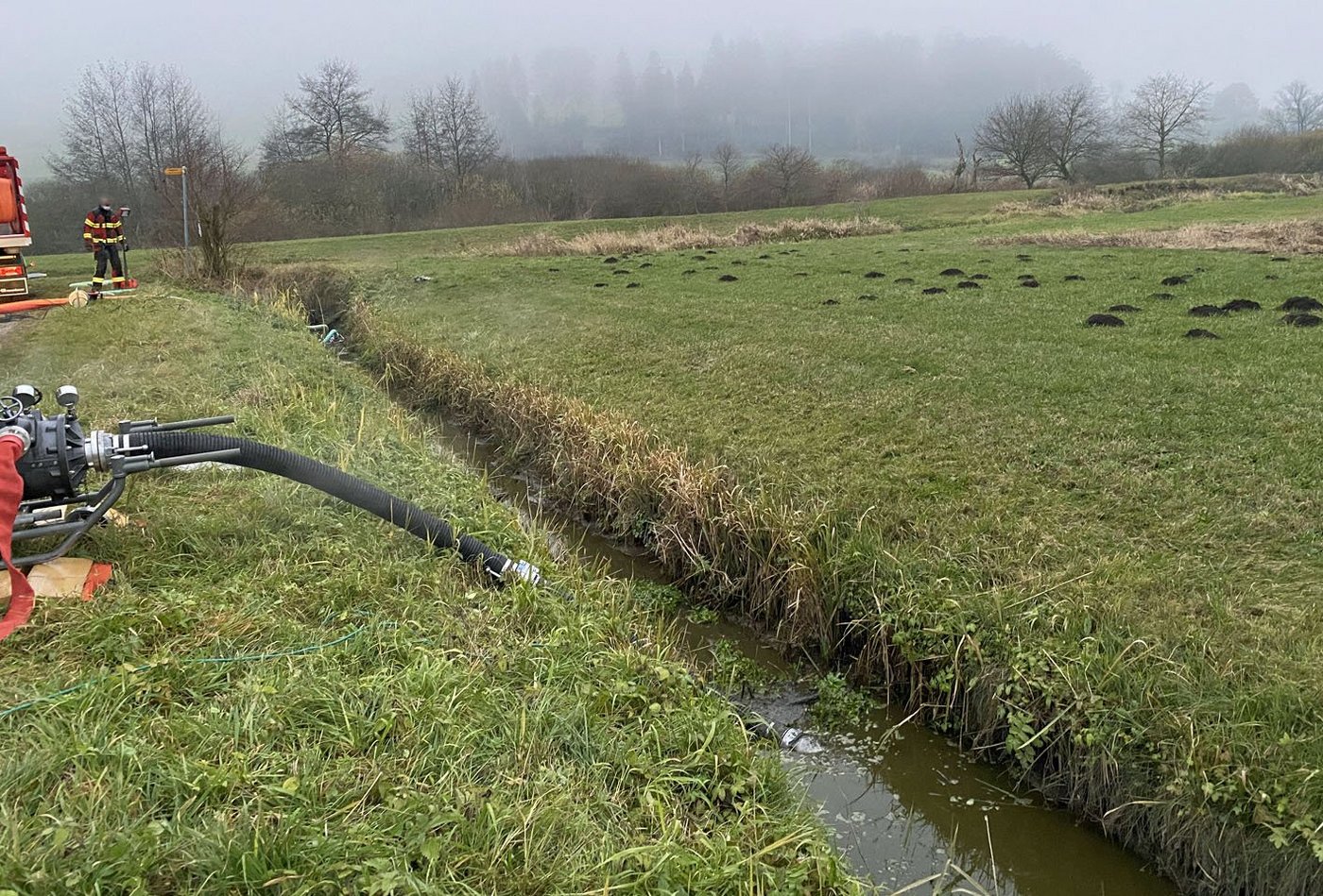Die Feuerwehr pumpt mit Gülle verschmutztes Wasser aus dem Stigegrabe ab. (Bilder Luzerner Polizei)