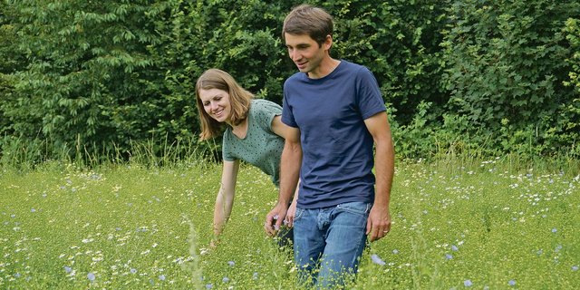 Anja und Reto Widmer spazieren über ein Feld mit Öllein. Die beiden bewirtschaften ihren gemeinsamen Biohof in Heimiswil seit 2016. Seither haben sie den Betrieb schrittweise weiterentwickelt und vielseitiger gemacht.(Bild Deborah Rentsch)