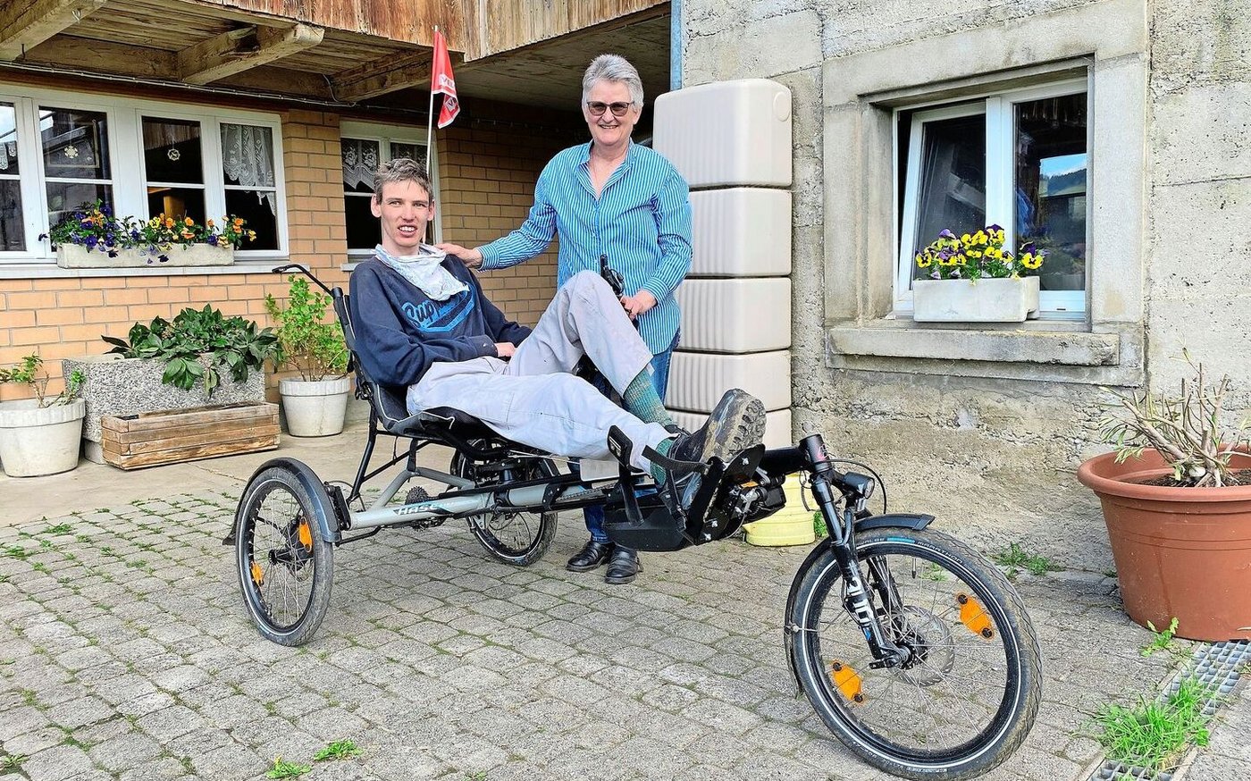 Anita Binker mit ihrem Sohn Adrian Reusser, der stolz sein Spezial-Liegevelo vorführt, das ihm ein Stück Selbstständigkeit gibt.