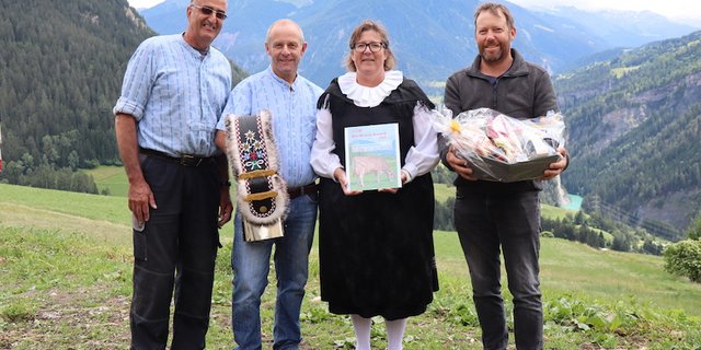 Als Anerkennung ihrer Leistung wurden Toni (mit Glocke) und Nicole Sigron (mit Bio Bruna Award) von Marco Parpan (l.) Lucas Margreth (r.) mit einem Früchtekorb beschenkt. (Bild vcd)