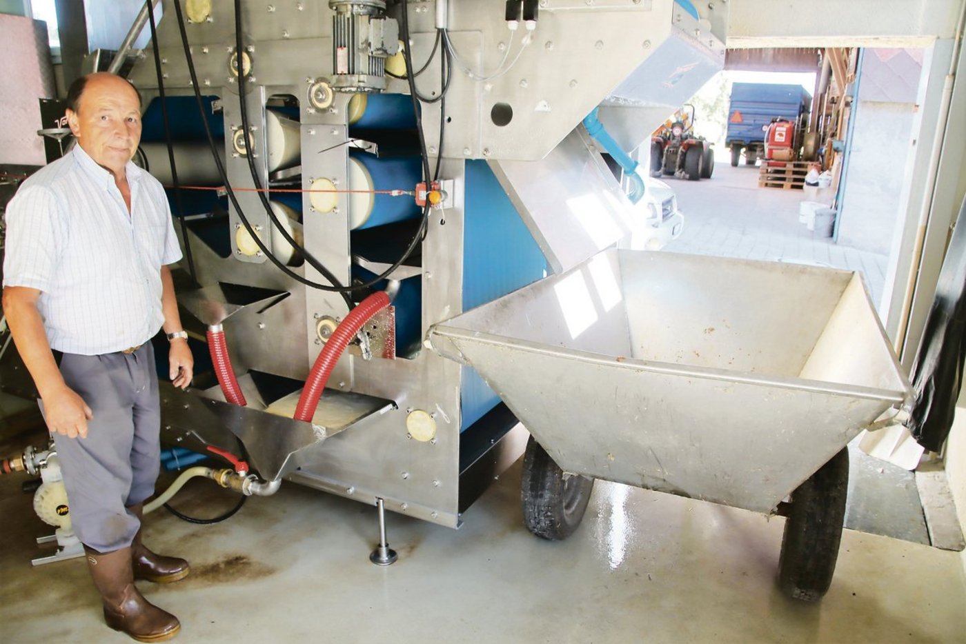 Ernst Bachmann beim Sammelbehälter unter der Presse. Im Behälter wird der frisch gepresste Saft aufgefangen. Danach wird er zum Klären und Abfüllen abgepumpt.(Bilder Roland Müller)