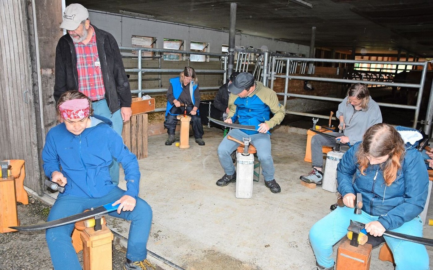 Das richtige Dengeln des Sensenblattes will gelernt sein: Kursleiter Daniel Scheidegger überwacht das Ganze und gibt wertvolle Tipps.