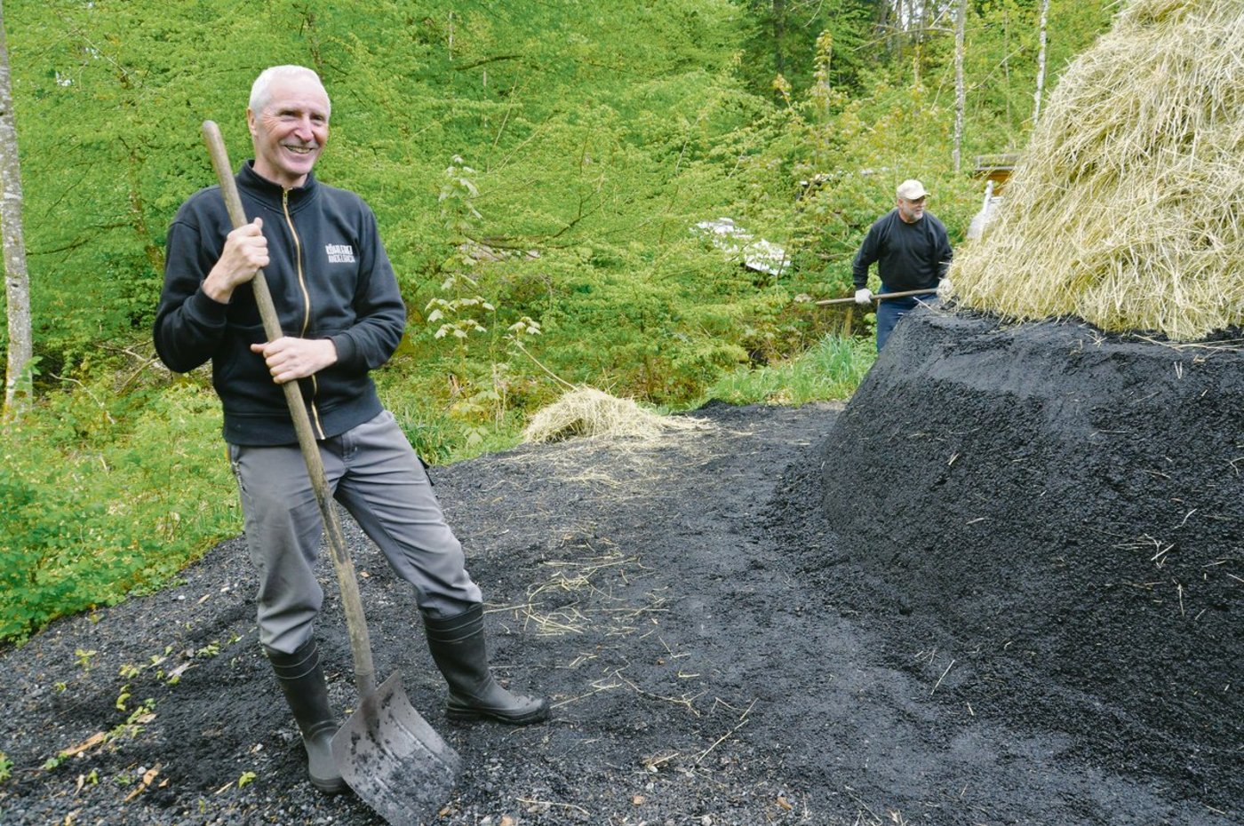 Peter Dietschweiler und sein Team überziehen den Meiler mit der «Löschi», einer luft- und wasserdichten Schicht aus Kohlenstaub und -griess. (Bilder Alexandra Stückelberger)