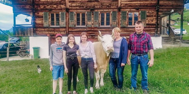 Tanja und Abraham Aellig mit den Kindern Martina, Ursina und Andrin. An der Halfter die Kuh Stella.