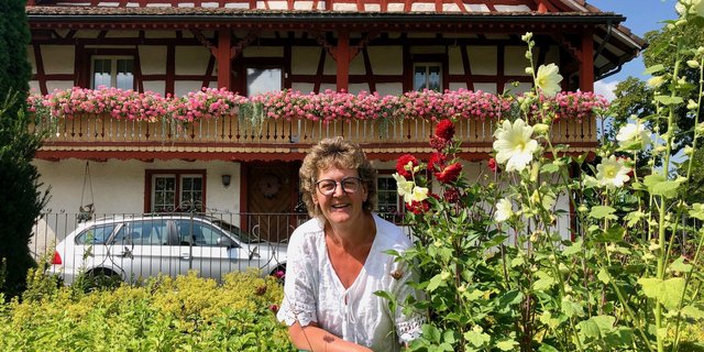 Ihre Blumen sind für sie eine Quelle der Kraft: Huguette Schwager vor dem Bauernhaus, das um 1760 als Teil des Klosters Tänikon gebaut wurde. Seit 1828 lebt die Familie Schwager darin. (Bild Jeanne Woodtli)