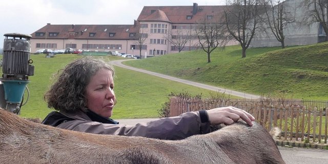 Physiotherapeutin Simone Rickenbach zeigt den Teilnehmerinnen einen Griff an einer Braunviehkuh.