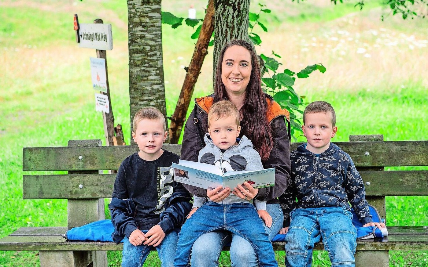 Sahra Brun-von Flüe mit ihren drei Buben (v. l.) Noah (6,5), Fabio (2,5) und Dario (4,5) am Büechli lesen beim Start des Themenweges bei der Bohrplatte Finsterwald.