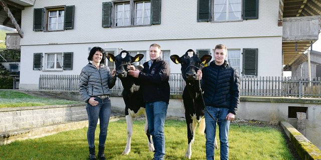Ruedi Sommer mit seinem Sohn Fabian und seiner Lebenspartnerin Renate Lüthi, mit den Kühen Brokaw Gandria und Smaragd Claire. (Bild Peter Fankhauser)