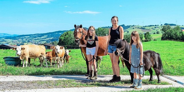 Larissa mit ihrem Pony Dino, Martina Wicki und Lea mit dem Shetty Leni. Die betriebseigenen Simmentaler-Mutterkühe mit ihren Kälbern beobachten die Szene.