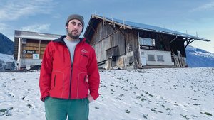 Michael Durrer vor den Gebäuden auf Heubüeli. Der alte Stall wurde bereits mit PV-Modulen belegt (r.). Bald werden solche mit viel Eigenleistung auch auf dem Dach und der Fassade der neuen Scheune montiert. 