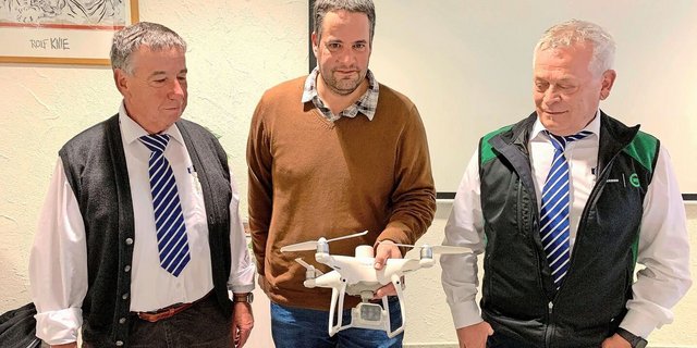 Präsident Toni Moser (l.) und Geschäftsführer Sepp Erni (r.) lassen sich von Marco Landis eine Drohne mit Wärmebildkamera für den Einsatz in der Landwirtschaft erklären.  